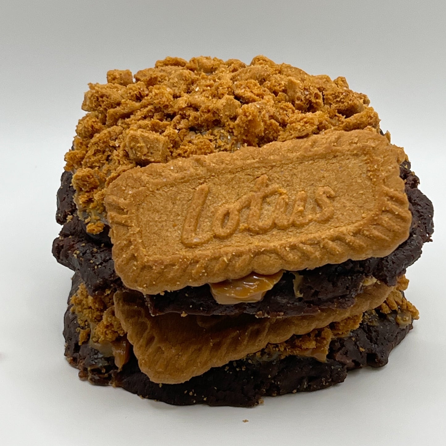The Caramel Biscoff Cookie broken in half, revealing the gooey caramel and Biscoff layers inside.
