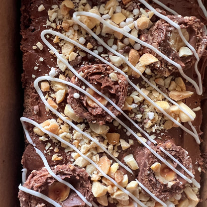 Decadent Chocoholic Hazelnut Brownie adorned with Ferrero Rocher, peanuts, and a heavenly white chocolate drizzle